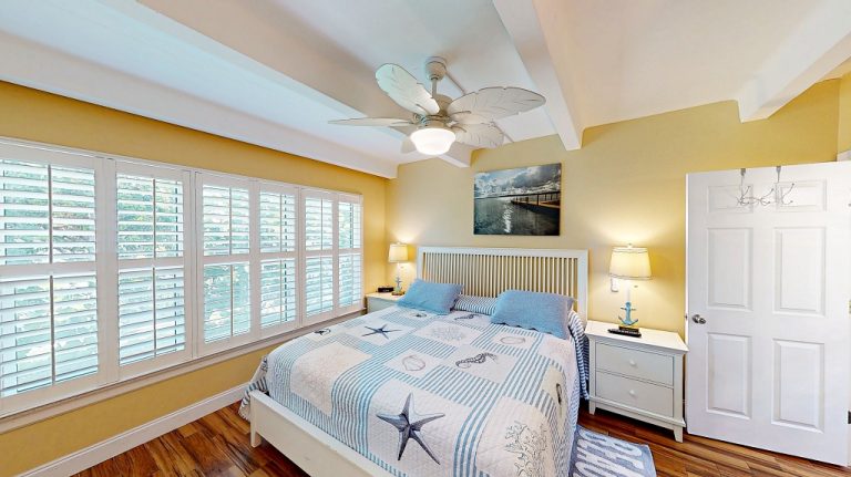 Master bedroom with coastal decor and plantation shutters at Ocean Club South